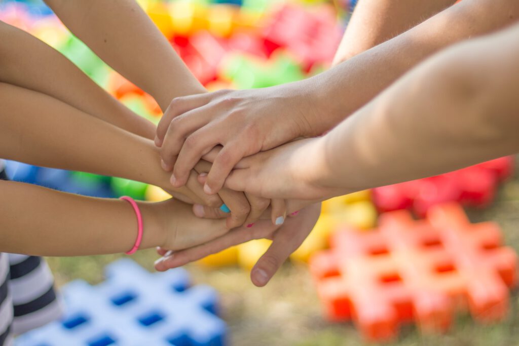 Das Bild zeigt übereinandergelegte Kinderhände